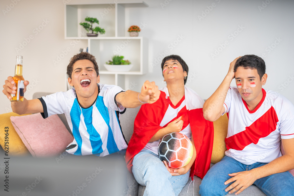 Fototapeta premium Friends from rival teams excitedly watching a soccer game