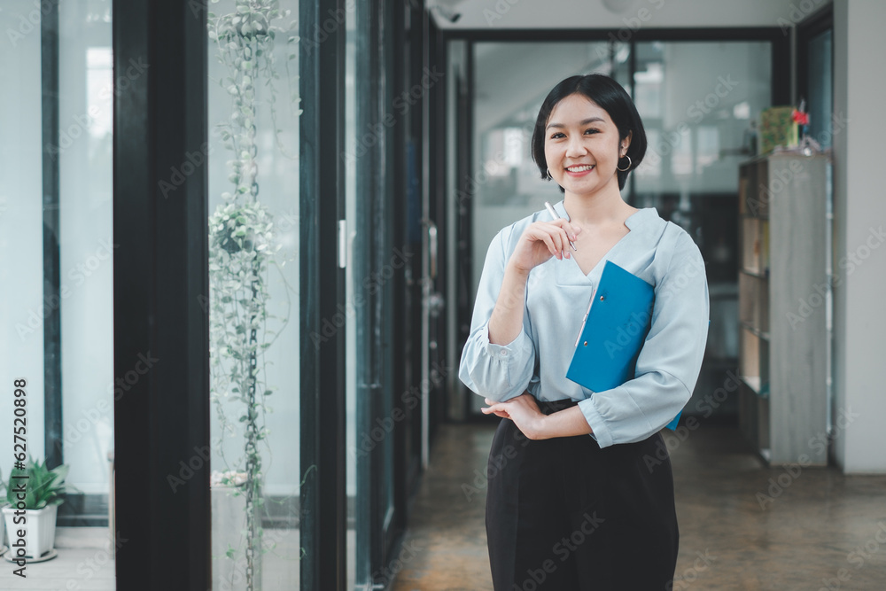 Successful businesswoman standing in creative office and looking at camera. Woman entrepreneur in a coworking space smiling. Successful businesswoman standing in creative office and looking at camera. Woman entrepreneur in a coworking space smiling.