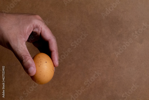 Tableau sur toile a man's hand holding a stained egg with his fingers giving the feeling of handin