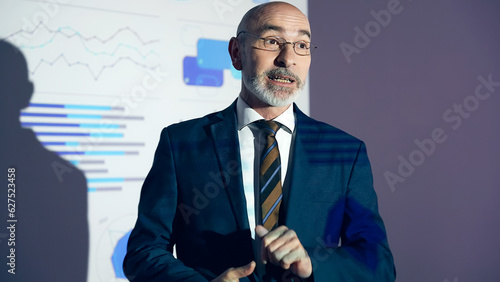 Принти на полотні A middle-aged Caucasian business person giving a presentation using a projector screen