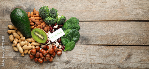Healthy products rich in vitamin E on wooden background with space for text
