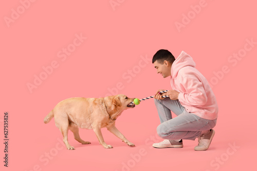 Young man playing with cute...