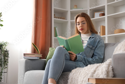 Young woman reading book on...