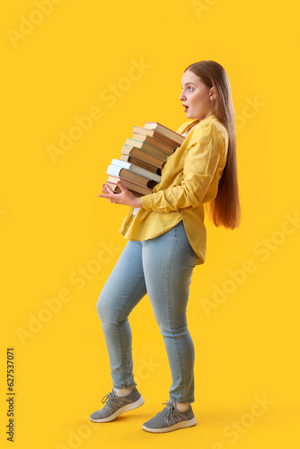 Young woman with stack of b...