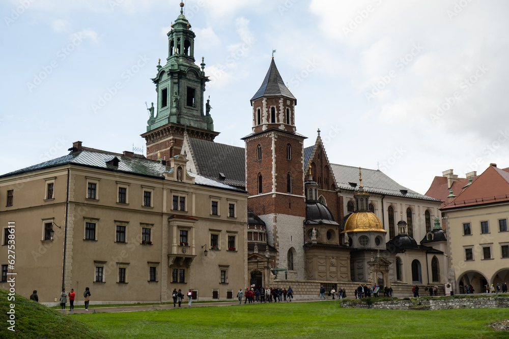 Summer view of Wawel Royal Castle in Krakow, Poland. Historically and culturally important site in Poland. Flowers on foreground. Beautiful sightseeing with Wawel Royal Castle and colorful flowers in Summer view of Wawel Royal Castle in Krakow, Poland. Historically and culturally important site in Poland. Flowers on foreground. Beautiful sightseeing with Wawel Royal Castle and colorful flowers in