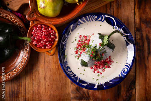 Chiles en Nogada, Typical dish from Mexico. Prepared with poblano chili stuffed with meat and fruits and covered with a walnut sauce. Named as the quintessential Mexican dish for national holidays. photo