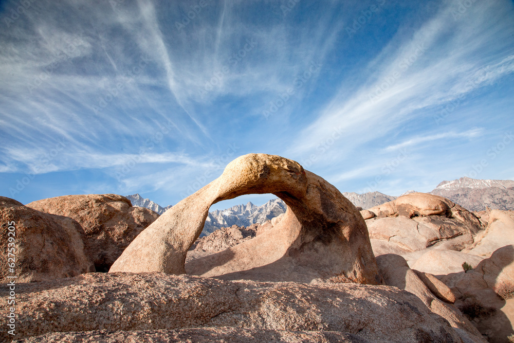 Mobius Arch in Alabama Hills. Blue sky with light clouds. Mount Whitney in the Background. Mobius Arch in Alabama Hills. Blue sky with light clouds. Mount Whitney in the Background.