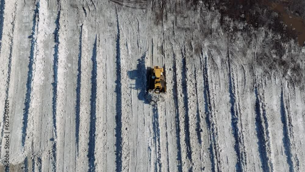 Birds eye view drone shot snowplow clearing and moving snow in Canada Birds eye view drone shot snowplow clearing and moving snow in Canada