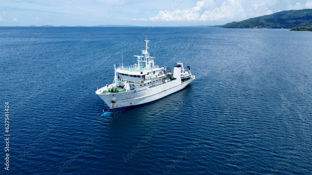 Ship in the sea . Research vessel at sea. Aerial view of a large white ship parked near the shore of a tropical island. Ship in the sea . Research vessel at sea. Aerial view of a large white ship parked near the shore of a tropical island.