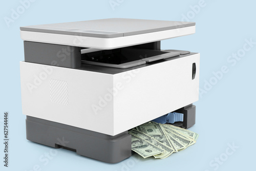 Laser printer with dollar banknotes on light background