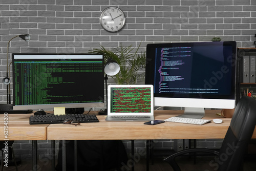 Programmer's workplace with programming code on computer monitors