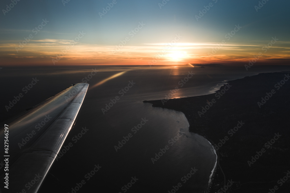 Flying over Point Dume Malibu with a wing of an aircraft in view at Sunset