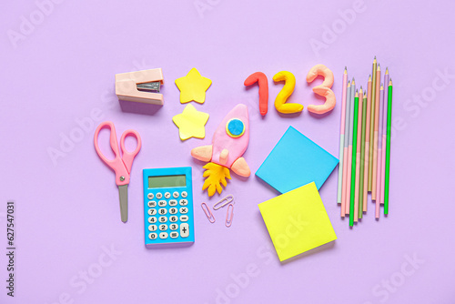 Rocket and numbers made of plasticine with stationery on lilac background photo