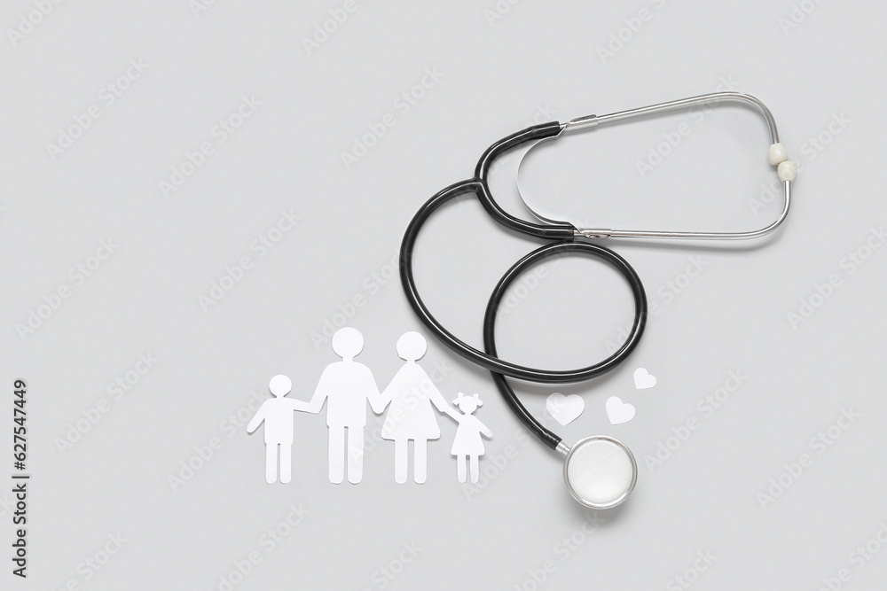 Figures of family with stethoscope on grey background. Health care concept Figures of family with stethoscope on grey background. Health care concept