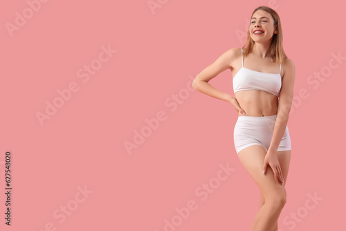 Young woman with cellulite problem on pink background