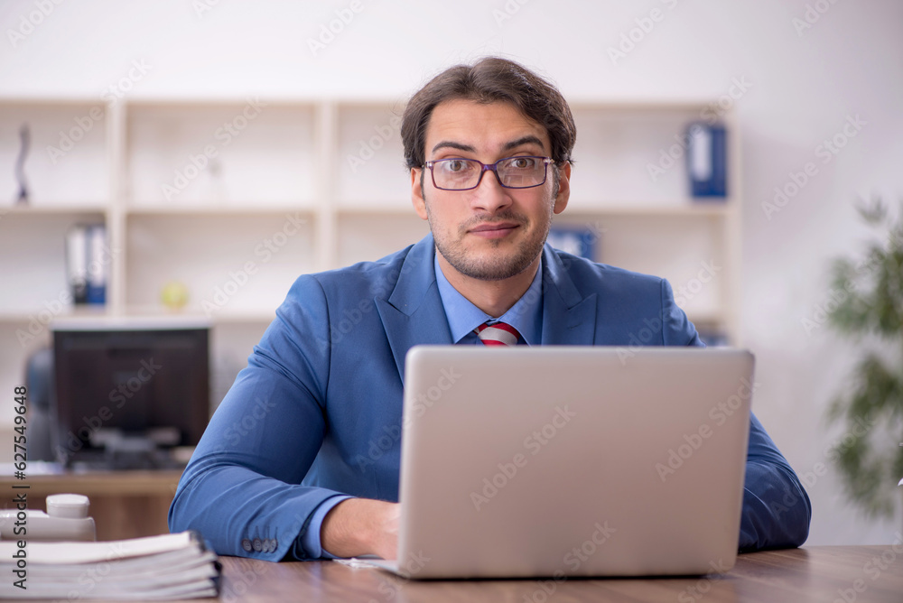 Young male employee working in the office Young male employee working in the office