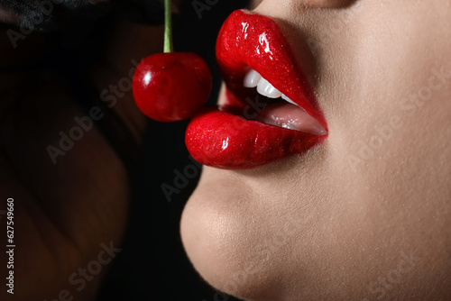 Photo Beautiful woman with red lips and cherry on dark background, closeup