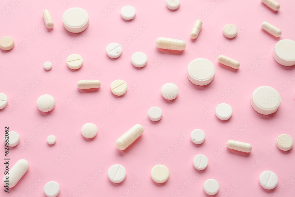 Many different pills on pink background Many different pills on pink background