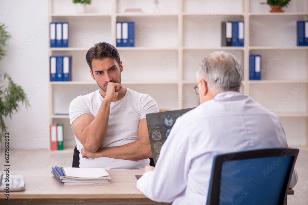 Young male patient visiting old male doctor radiologist Young male patient visiting old male doctor radiologist