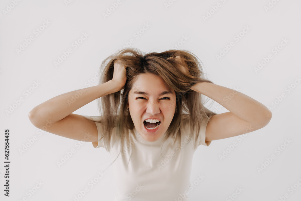 Angry face of asian woman in white t-shirt isolated on white.