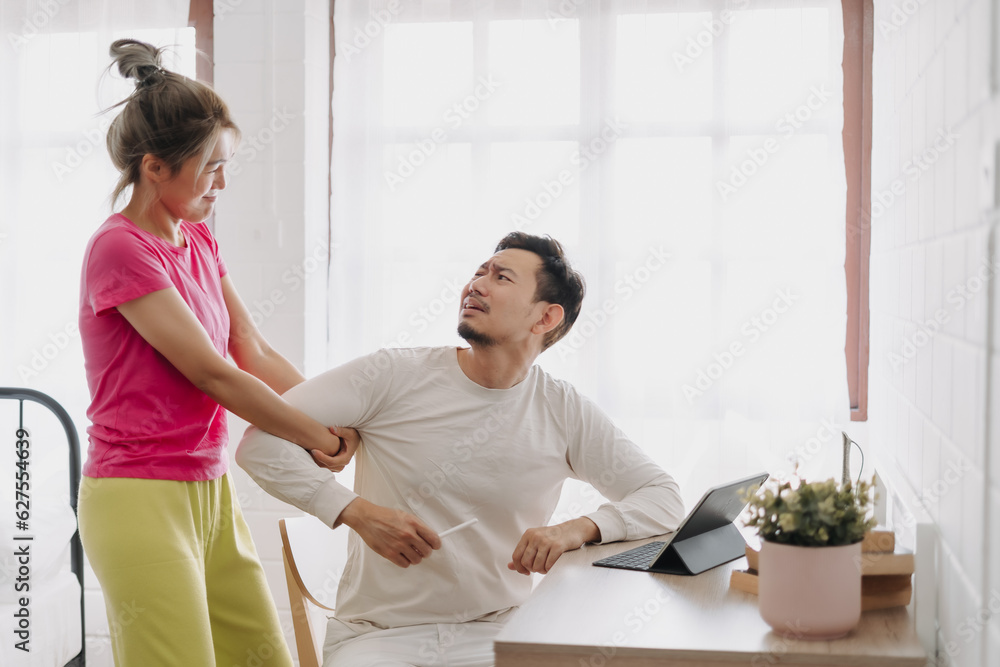 Fototapeta premium Asian wife asking husband to stop working and watching with computer tablet.