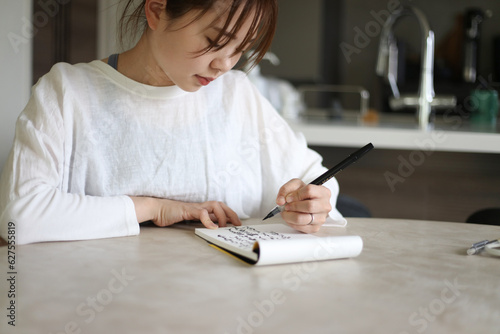  筆ペンで字を書く女性