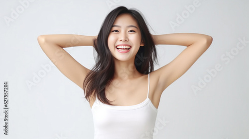 A young and pretty woman in a white underwear dress exudes joy and relaxation  raising her arms wide with a cute smile  revealing her smooth armpits against a pristine white background. Generative AI.