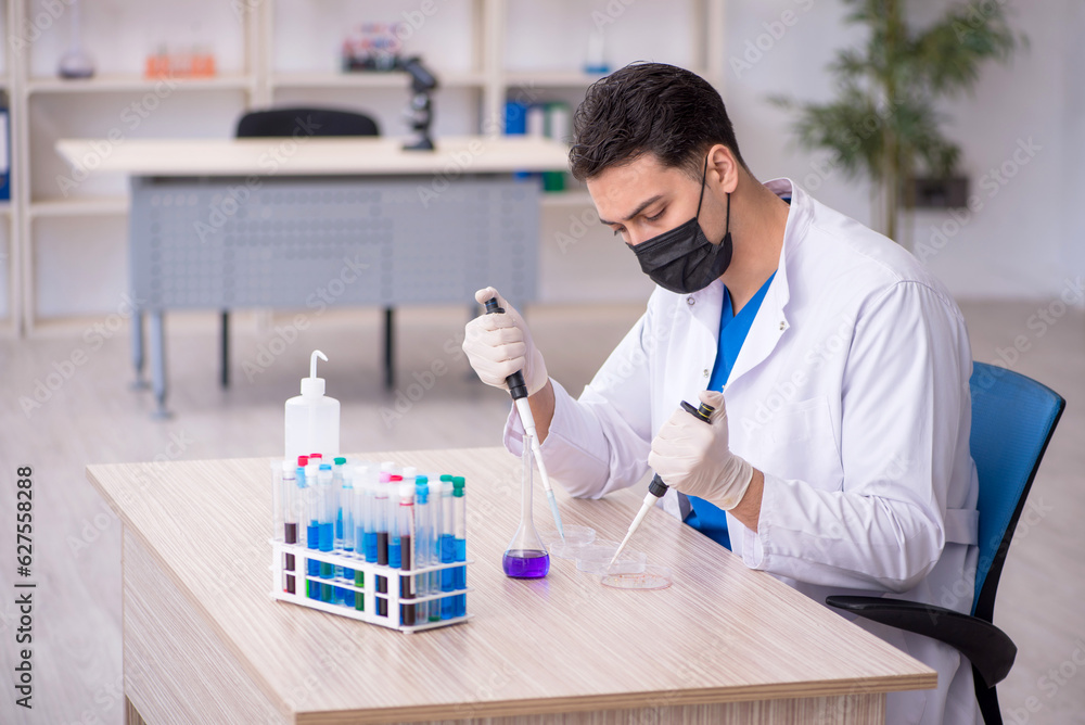 Young male chemist working at the lab