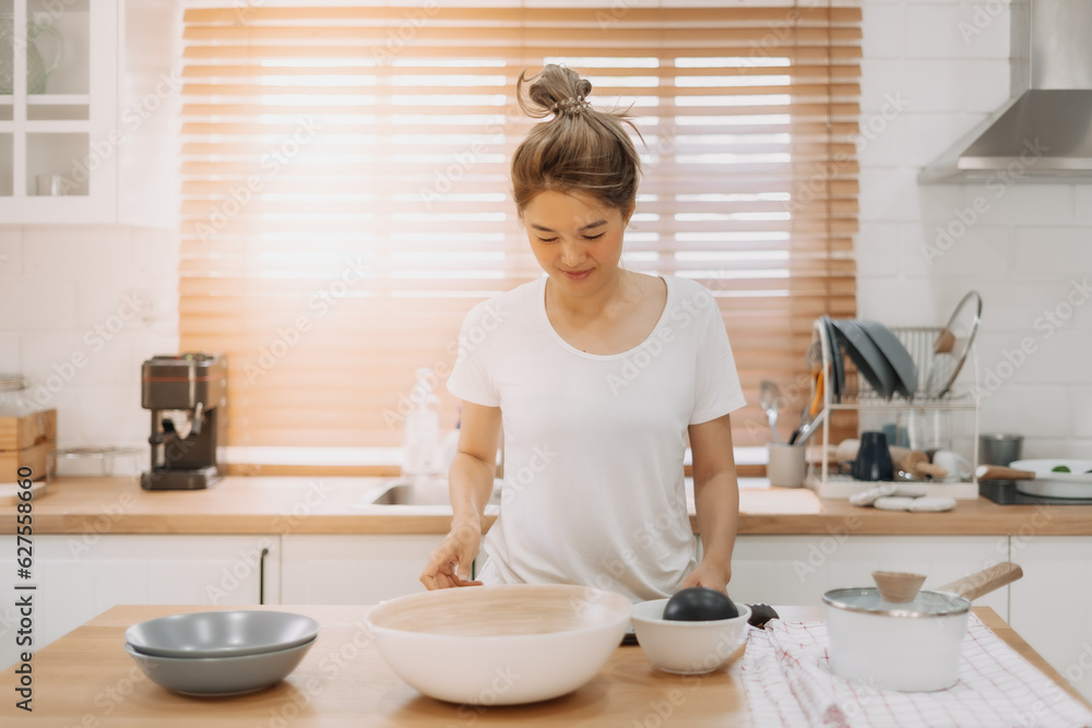 Portrait of happy asian woman preparing breakfast in the kitchen in the morning.
