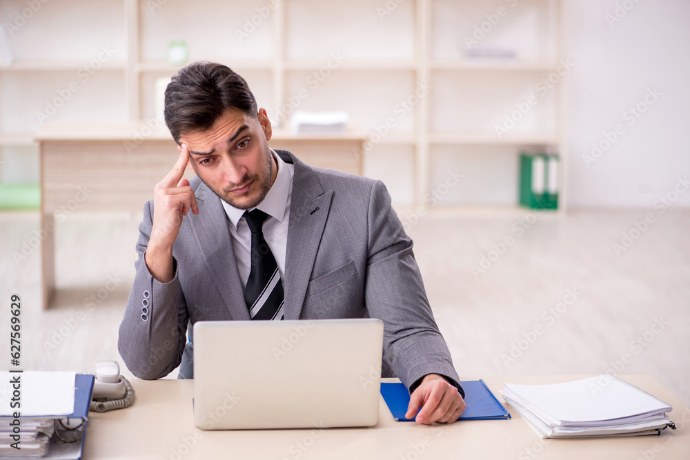 Young male employee working in the office Young male employee working in the office