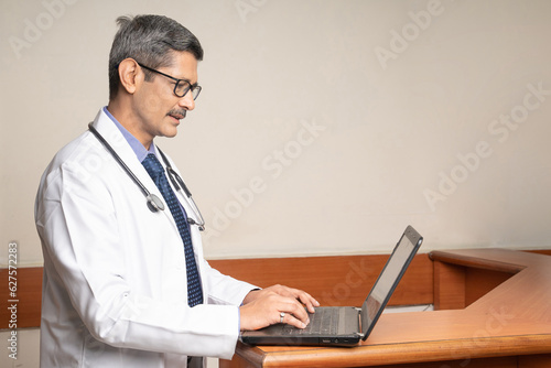 Doctor working on laptop in his medical office.