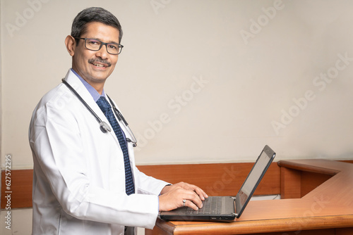 Doctor working on laptop in his medical office.