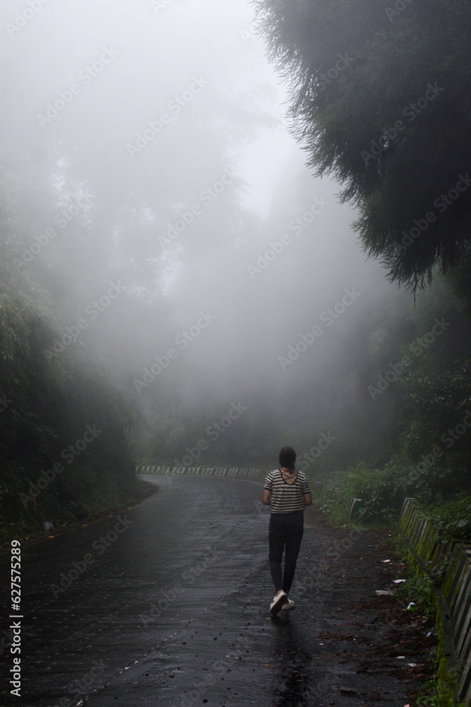 Woman walking on the mountain in fog Woman walking on the mountain in fog