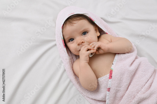 Φωτογραφία Cute little baby with pacifier in hooded towel after bathing on bed, top view