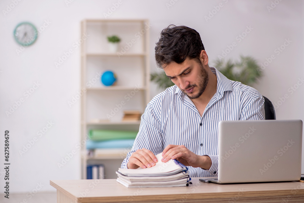 Young male employee student working in the office Young male employee student working in the office