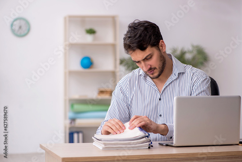 Young male employee student working in the office