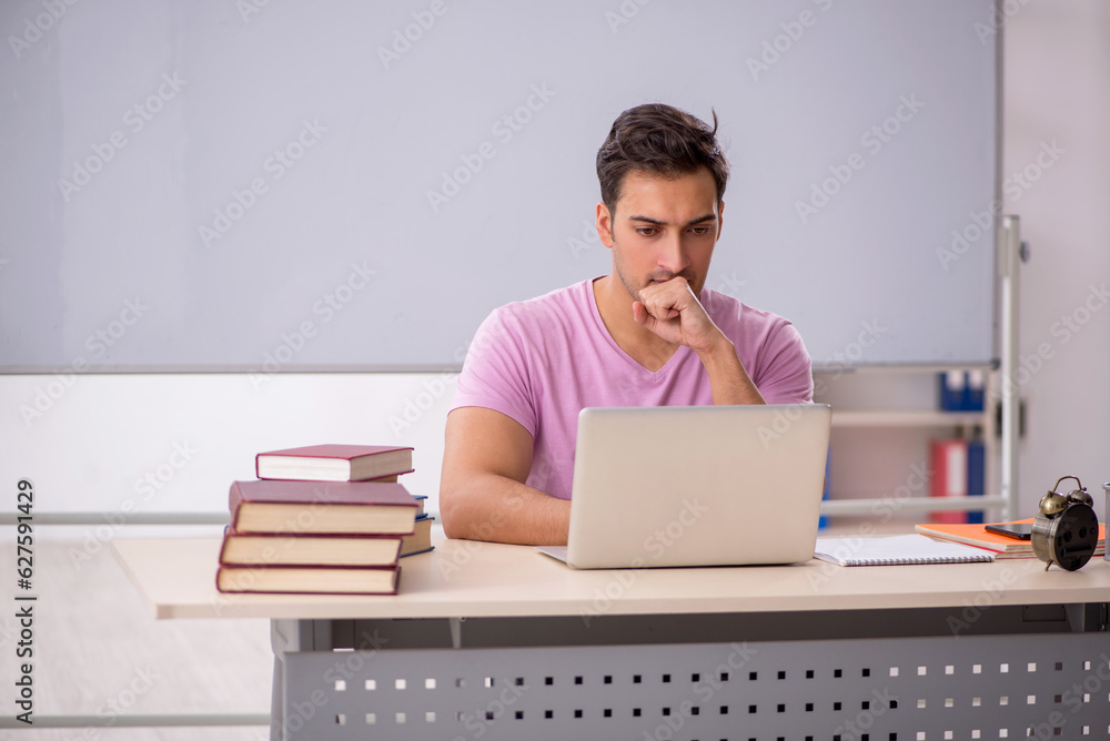 Young male student preparing for exams in the classroom Young male student preparing for exams in the classroom