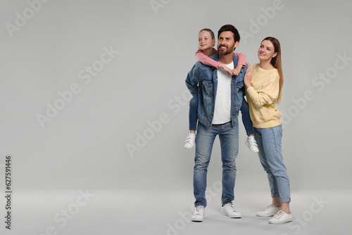 Happy family on light grey background, space for text