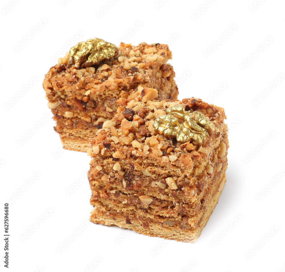 Pieces of layered honey cake with walnuts on white background Pieces of layered honey cake with walnuts on white background