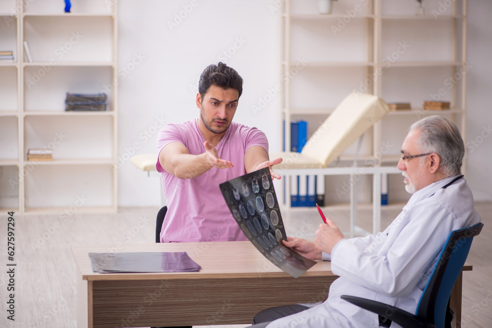 Fototapeta premium Young male patient visiting old male doctor radiologist