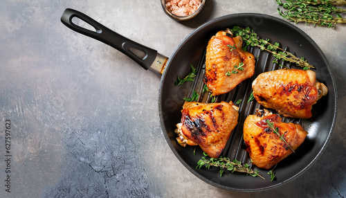Fotografiet grilled chicken thighs in a frying pan with fresh thyme, view from above, flatla