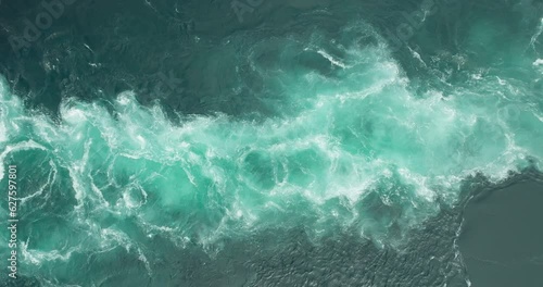 Spinning whirlpool and vortex in azure blue Saltstraumen maelstrom current; drone