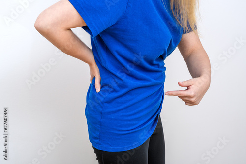 Kobieta pokazująca na swój brzuch, trzymająca się za nerkę 