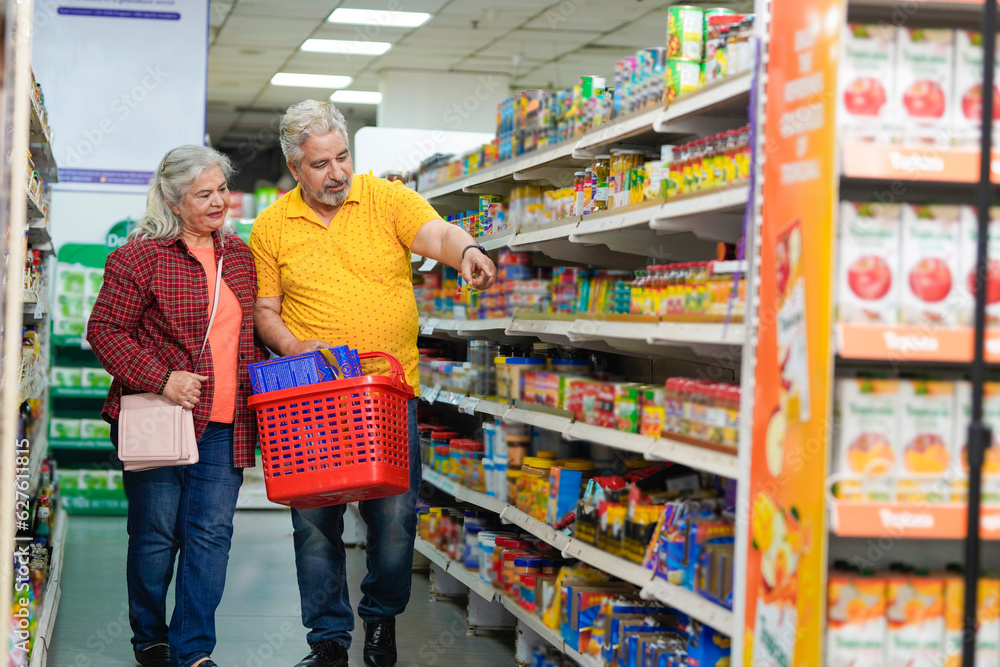 Senior indian couple purchasing together at grocery shop