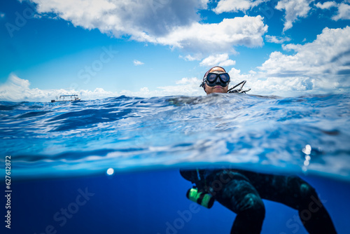 Half and Half Shot of a Scuba Diver on the Ocean Surface © feel4nature