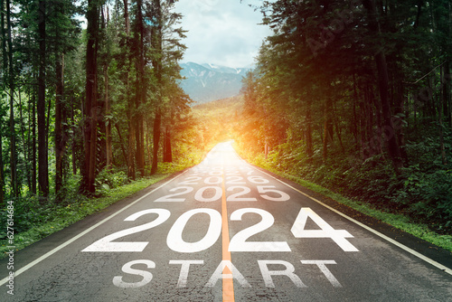 New year 2024 or 2024 planning concept of success beginning. Text 2024 written on the middle of paved road with sunset. New year plan, goals, challenges, resolutions.