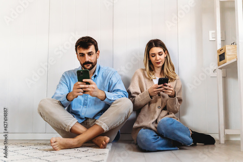 Murais de parede Couple addicted to smartphones ignoring each other at home