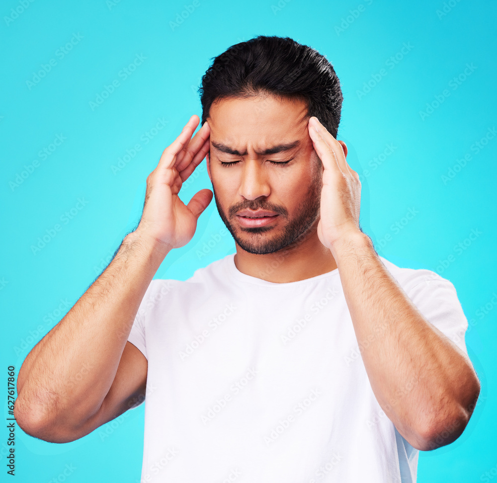 Stress, pain and man with a headache, burnout and health problem on a blue studio background. Male person, anxiety and model with a migraine, frustrated and tension with strain, fatigue and pressure Stress, pain and man with a headache, burnout and health problem on a blue studio background. Male person, anxiety and model with a migraine, frustrated and tension with strain, fatigue and pressure