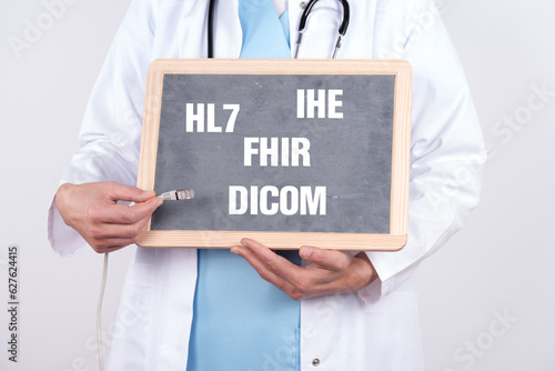 Arzt mit einer Tafel auf der HL7 DICOM IHE und FHIR steht. Konzept medizinische Standards in der IT