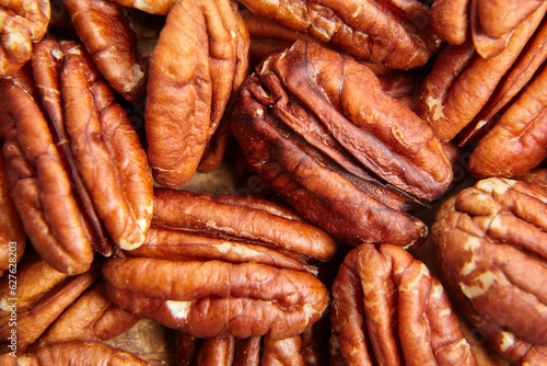 Pecan nuts kernel texture background closeup. Heap of peeled pecan halves. Closeup reveals pecan nuts intricate texture